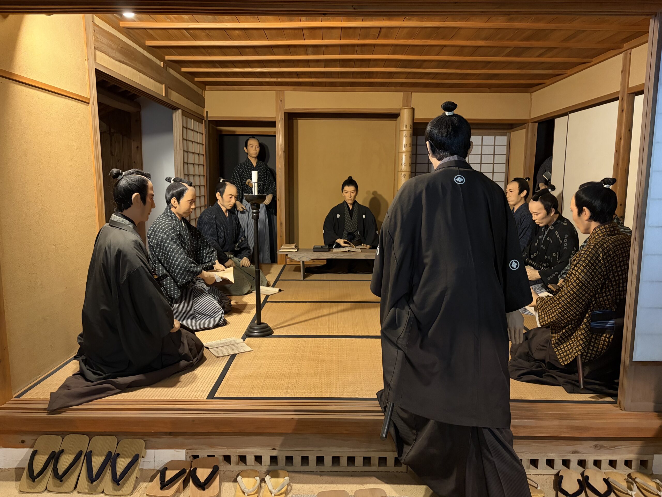 畳の部屋で学ぶ人たちを人形で表した展示