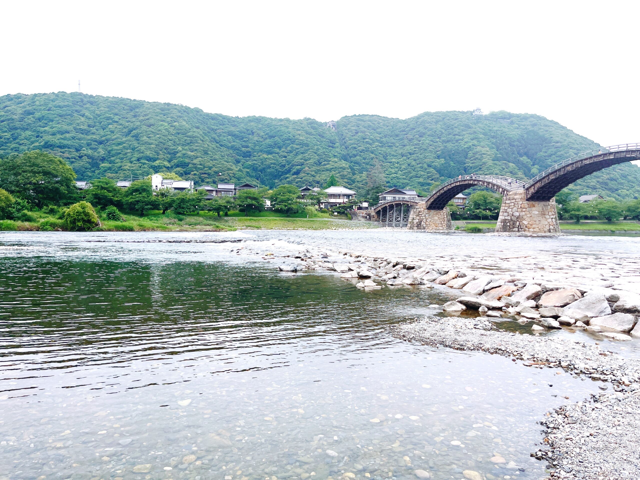 川の流れとアーチを描く木の橋